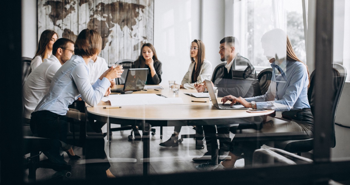 Groupe de personnes en réunion de networking autour d’une grande table, échange professionnel entre entrepreneurs